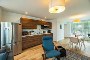 kuchnia z lodówką i stołem z krzesłami w obiekcie NN War Eagles Nest Ravens Ridge 1bed 1 bath w mieście Whitehorse