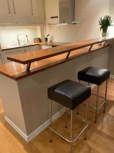 a kitchen with a counter with two bar stools at Super sentralt for 2 personer in Lillestrøm