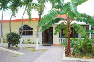 un bâtiment avec des palmiers en face de celui-ci dans l'établissement Villa Familiar en Río San Juan con Wifi BBQ Piscina @drvacationsrental, à Río San Juan