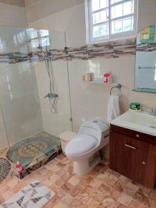 a bathroom with a shower and a toilet and a sink at Villa Familiar en Río San Juan con Wifi BBQ Piscina @drvacationsrental in Río San Juan