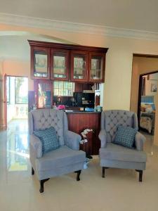 a living room with two chairs and a cabinet at Villa Familiar en Río San Juan con Wifi BBQ Piscina @drvacationsrental in Río San Juan