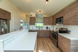 a large kitchen with white counter tops and wooden cabinets at NN - The Lavendar A - Whistlebend 2-bed 1-bath in Whitehorse