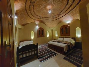a bedroom with two beds in a room with a ceiling at فيلا الريف السويسري in Tunis