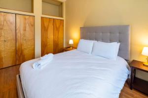 una camera da letto con un grande letto bianco con due lampade di NN - The Loft - Downtown 1-bed 2-bath a Whitehorse