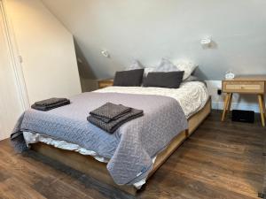 a bedroom with a bed with towels on it at Little House Annexe in Shotteswell