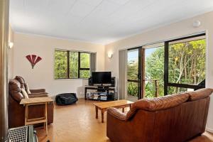 a living room with two couches and a tv at Waters Edge Golden Bay in Collingwood