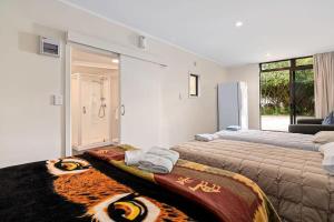 1 dormitorio con 2 camas y mantas en el suelo en Waters Edge Golden Bay, en Collingwood