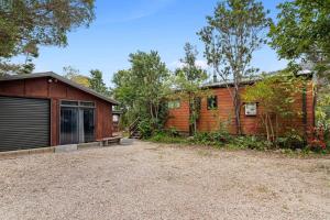 a home with a garage and a building at Waters Edge Golden Bay in Collingwood