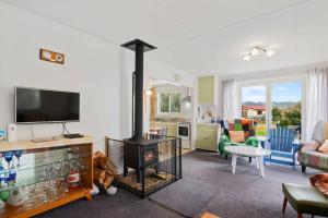 a living room with a fireplace and a tv at Sunset at Parapara Beach in Parapara 