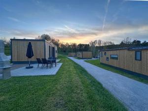 a backyard with a table and chairs and a umbrella at Holiday Village Seeblick - tiny house with lake view in Neunburg vorm Wald