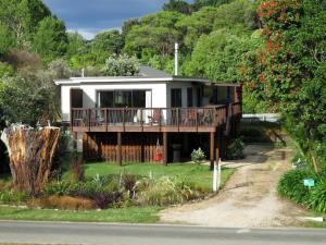 a house with a deck on the side of the road at Parapara Beach Escape in Parapara 