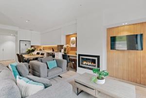 a living room with a couch and a fireplace at The Terrace at La Residence du Parc in Queenstown