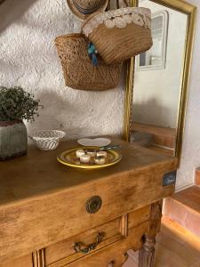 einen Tisch mit einem Teller Essen und einem Spiegel in der Unterkunft Le temps retrouvé Maison de village de charme in Caunes-Minervois