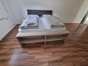 a bed in a room with a wooden floor at Gudzevic Ferien Unterkünfte A 2 in Gloggnitz