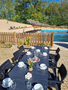 una mesa azul con platos y platos en ella en Appartement de 3 chambres avec piscine partagee jardin clos et wifi a Maurens, en Maurens