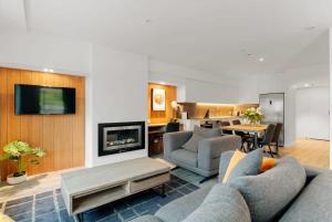 a living room with two couches and a fireplace at Vue Alpine - La Residence du Parc in Queenstown