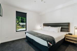 a bedroom with a large bed and a window at Coronet Bliss - La Residence du Parc in Queenstown