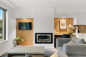 a living room with a couch and a fireplace at Residence Du Parc Apartment 8 in Queenstown