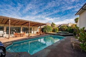 a swimming pool with a patio and a house at Alpine Retreat in Wanaka