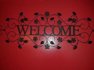 a welcome sign on a red wall with the word welcome at Dallas Private Room 6 in Dallas