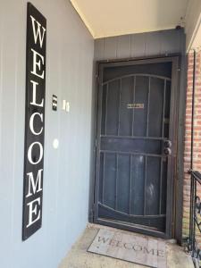 una puerta de garaje negra con un cartel al lado en Dallas Private Room 6 en Dallas