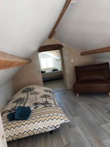 ein Schlafzimmer mit einem Bett und einem Sofa im Dachgeschoss in der Unterkunft Douce Campagne in Clermont-Créans