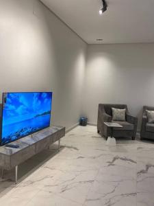 ein Wohnzimmer mit einem Flachbild-TV an der Wand in der Unterkunft شاليه السمو الفندقي in Umm Lajj