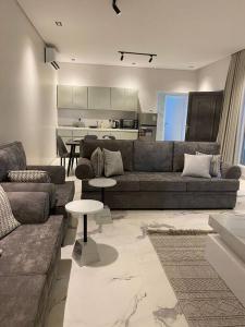 ein Wohnzimmer mit einem Sofa und einem Tisch in der Unterkunft شاليه السمو الفندقي in Umm Lajj