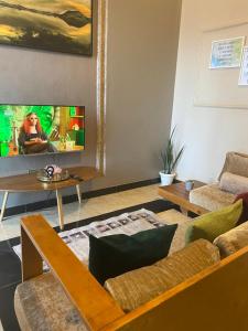 a living room with a couch and a tv at Casa del Court in Kampala