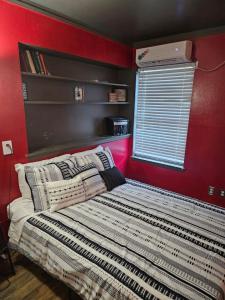 a bedroom with red walls and a bed with pillows at Dallas Private Room 6 in Dallas