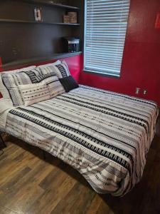 uma cama num quarto com uma parede vermelha em Dallas Private Room 6 em Dallas