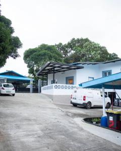 un bâtiment blanc avec des voitures garées dans un parking dans l'établissement Blue Home2 T3 meublé à Matoury pour 1 à 6 voyageurs., à Matoury