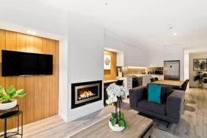 a living room with a couch and a fireplace at Penthouse Leisure in Queenstown