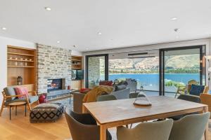 a living room with a table and chairs at Luxury Lake View Apartment in Wanaka