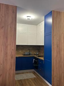 a kitchen with blue cabinets and a blue refrigerator at Apartament blisko stacji kolejowej in Mińsk Mazowiecki