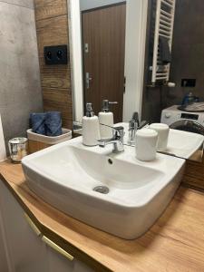a bathroom with a white sink and a mirror at Apartament blisko stacji kolejowej in Mińsk Mazowiecki
