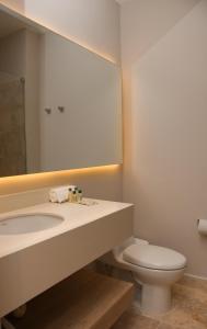 a bathroom with a sink and a toilet and a mirror at Ciela Hotel & Beach Club in Coveñas