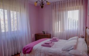 - une chambre aux murs roses avec un lit et des serviettes dans l'établissement Casa Santo Domingo de Silos, à Hacinas