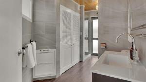 Un baño blanco con lavabo y espejo. en Greenstone Heights, en Queenstown 20 fotos más