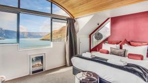 Un dormitorio con una cama y una ventana grande. en Greenstone Heights, en Queenstown