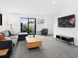 sala de estar con sofá y TV en Central Convenience on Armagh, en Christchurch