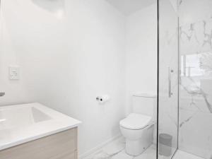 y baño blanco con aseo y ducha. en Central Convenience on Armagh, en Christchurch
