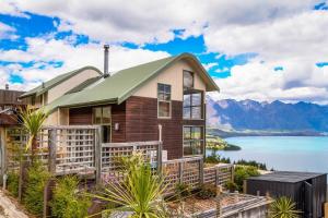 une maison sur une colline avec vue sur un lac dans l'établissement Ruby's Fernhill Vista, à Queenstown