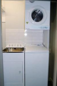 Waschmaschine und Trockner in einer kleinen Küche in der Unterkunft Stunning 1 Bedroom Studio Apartment in Queenstown