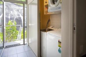 a small kitchen with a refrigerator and a window at Stunning 1 Bedroom Studio Apartment in Queenstown