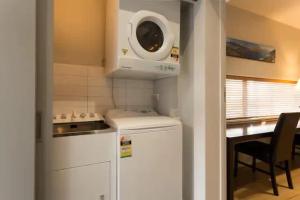 a kitchen with a stove and a microwave at Luxury 1 Bedroom Studio in Queenstown