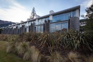 ein Haus auf einem Hügel mit hohem Gras in der Unterkunft Luxury 1 Bedroom Studio in Queenstown