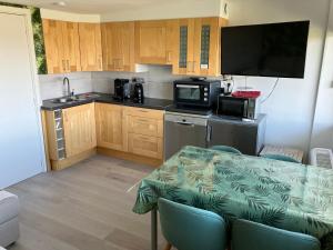 een kleine keuken met een tafel en een magnetron bij Bel Acacia in De Haan +11 foto's