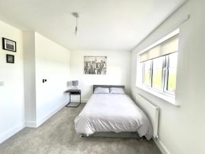 a white bedroom with a bed and a window at BRAND NEW 3 BEDROOM HOUSE WITH GARDEN AND FREE PARKING in Wednesbury