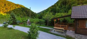 a building with a bench next to a path next to a mountain at Holiday house Bliss in Kumrovec